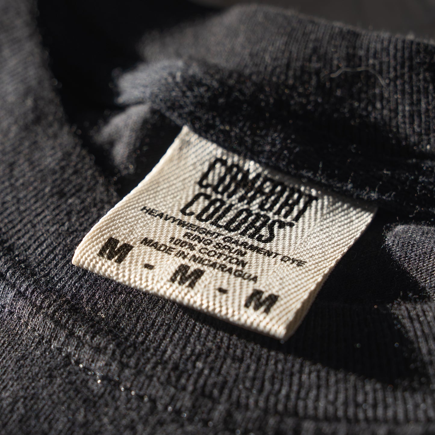 Close-up of a Comfort Colors label on a black garment.