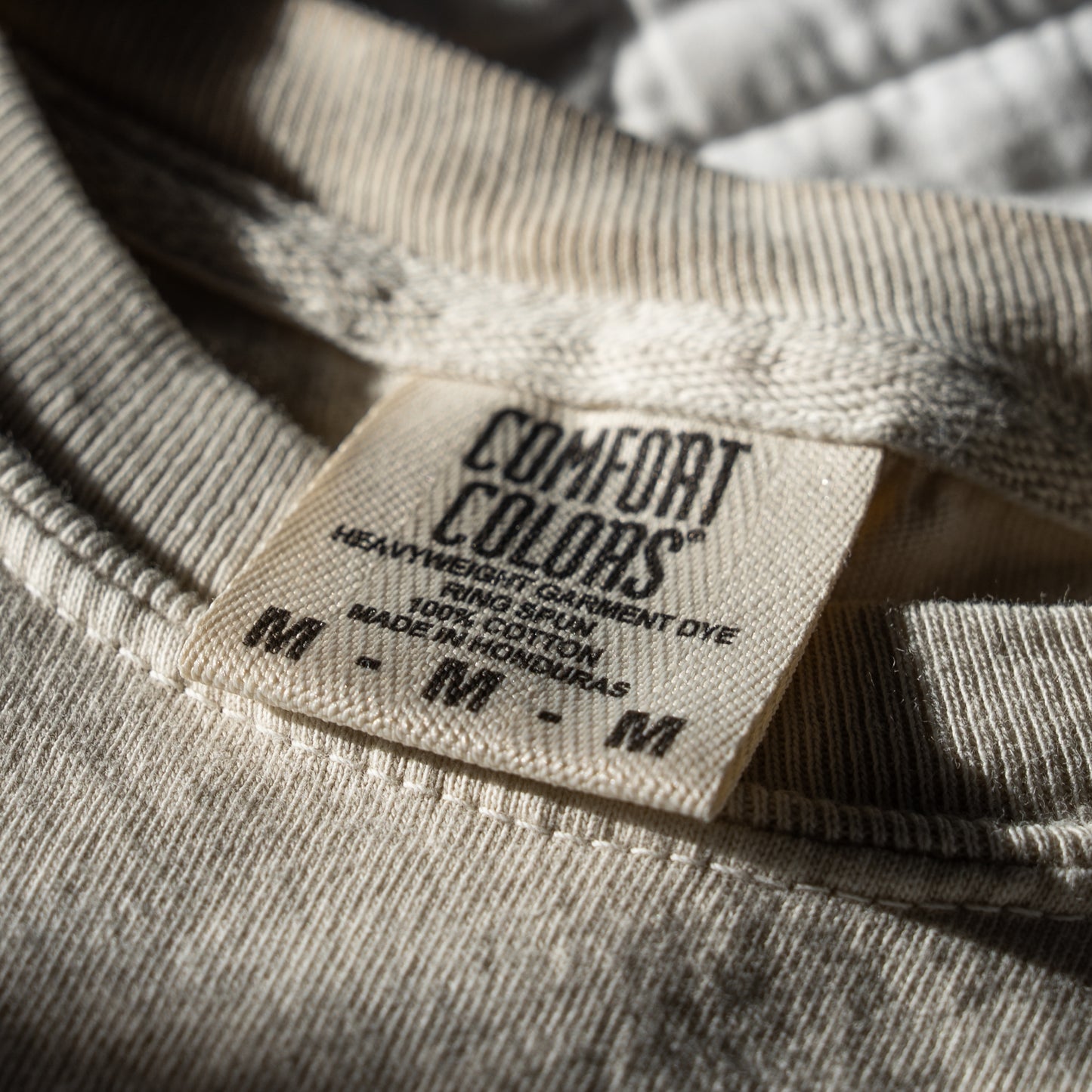 Close-up of a Comfort Colors label on a ivory garment.